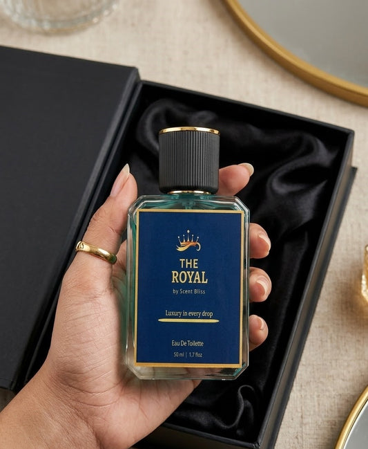Hand holding a bottle of 'The Royal' perfume with a black box in the background